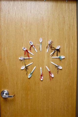 Plastic spoons arranged in a circle with various faces painted on the spoons