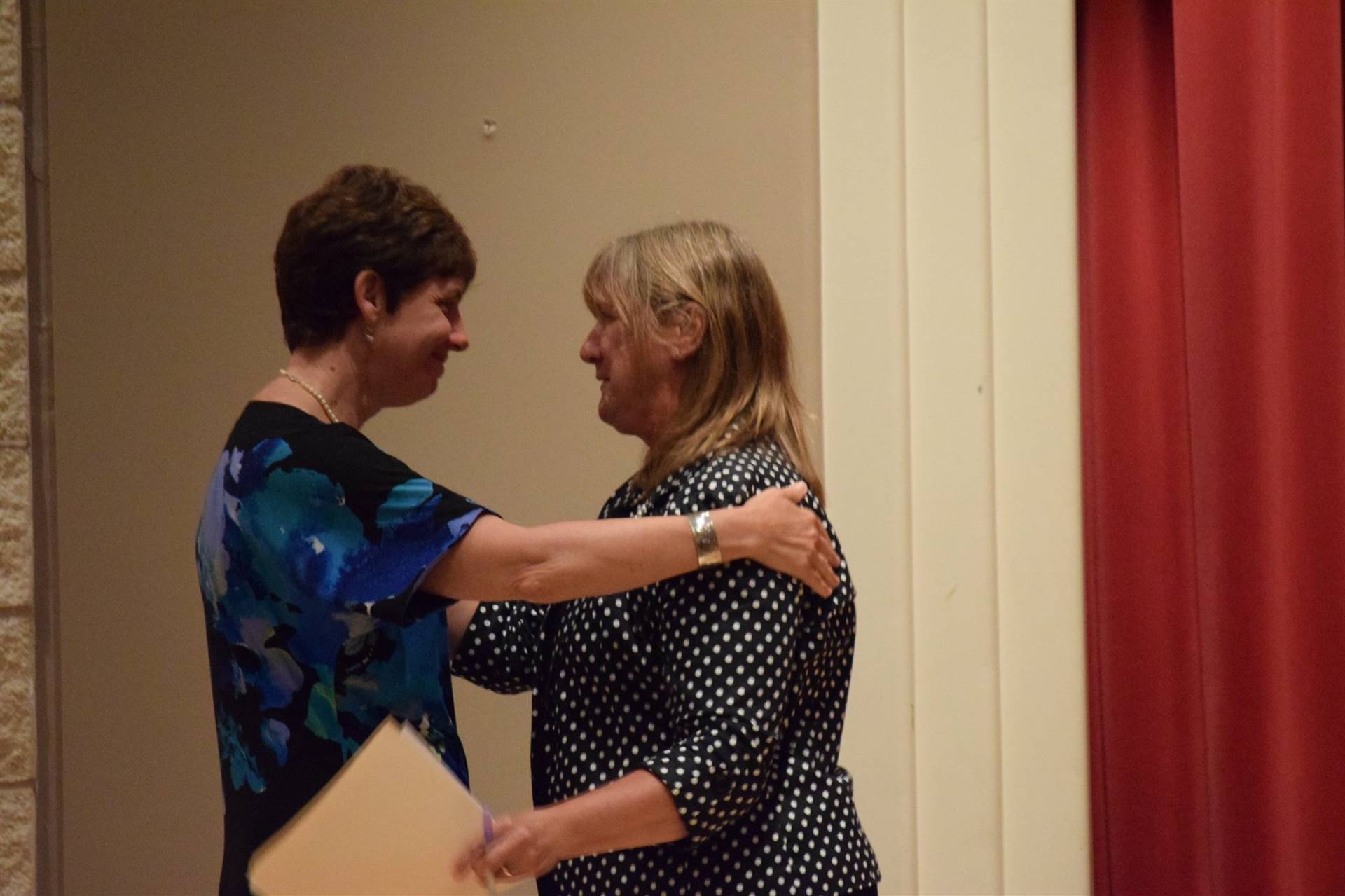 Honoree Dr. Nelson receiving a hug from a lady in attendance.