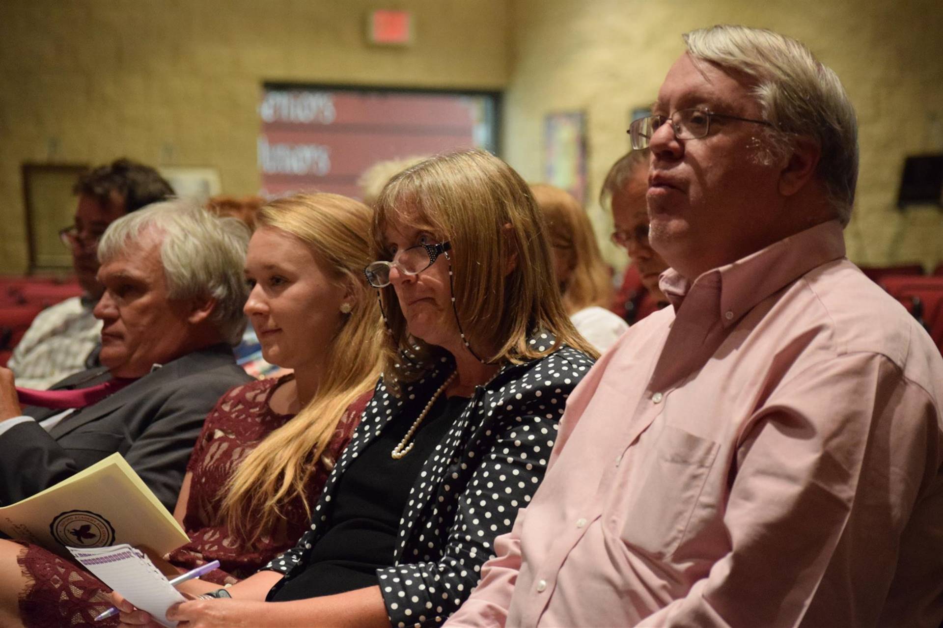 Group of people sitting in auditorium during the ceremony.