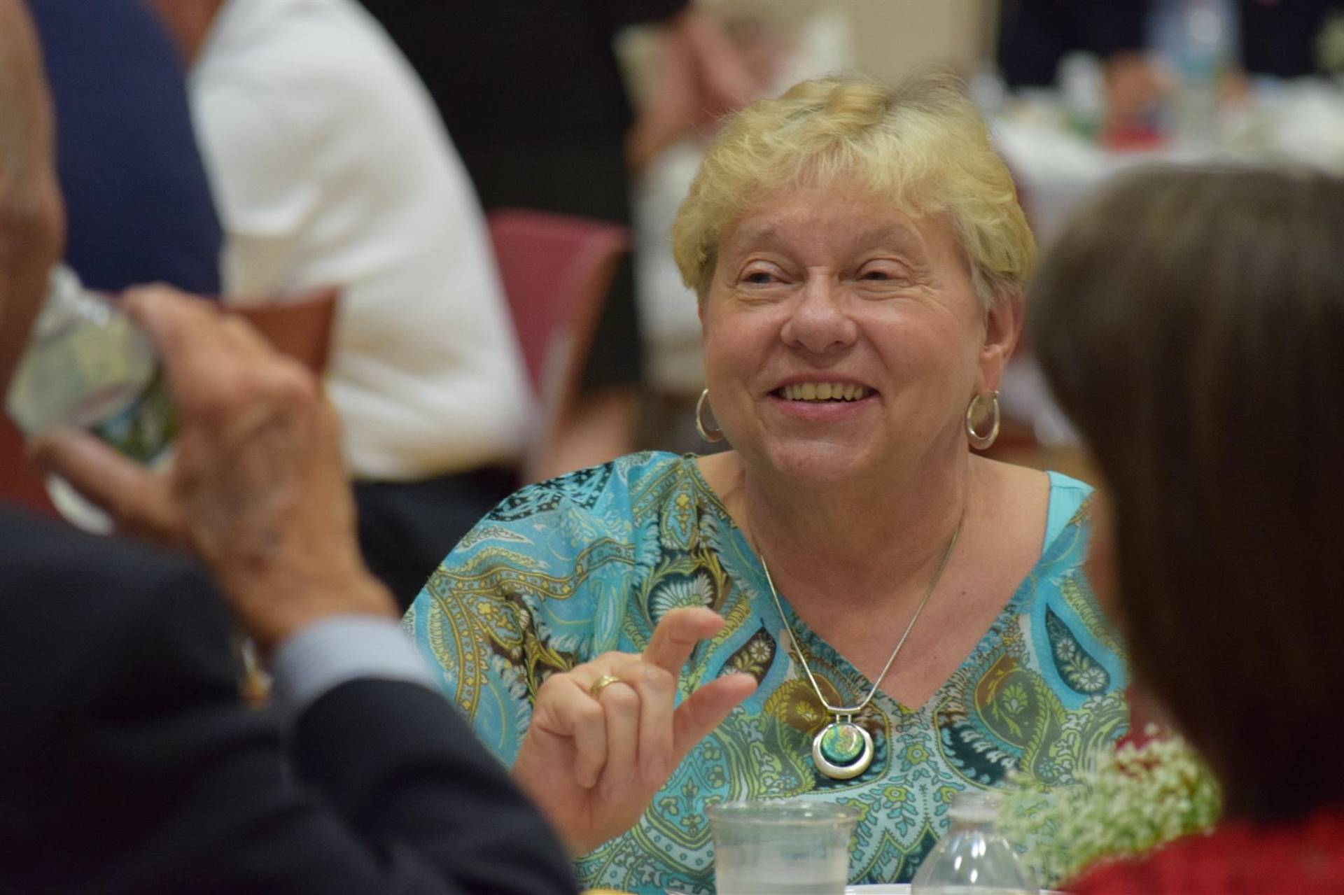 Woman attendee smiling at dinner.