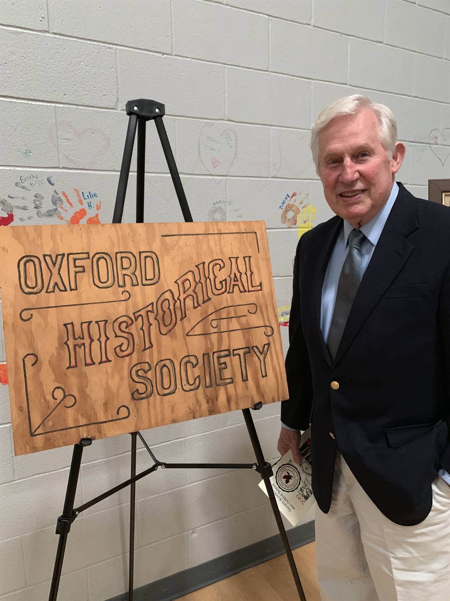 Mr. Lanfear posing with historical society sign display