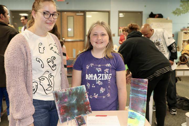 students standing near their paintings