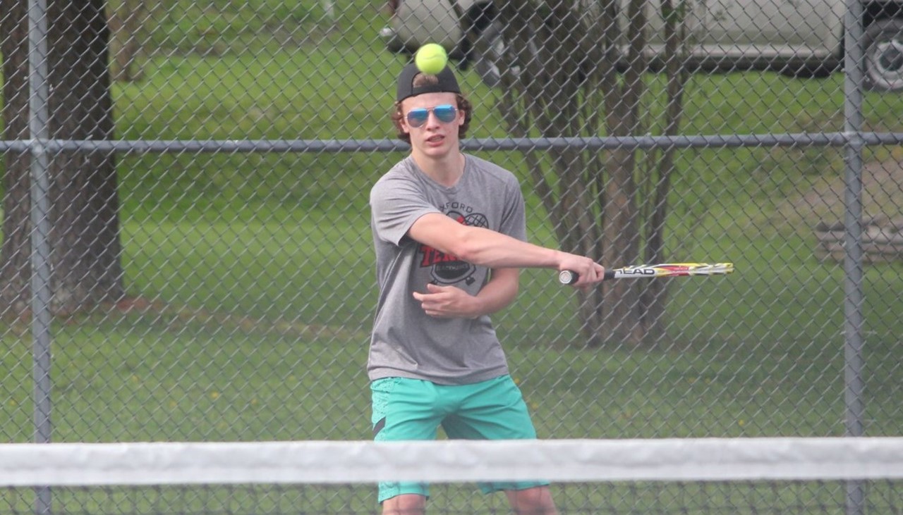 male tennis player swinging at the ball
