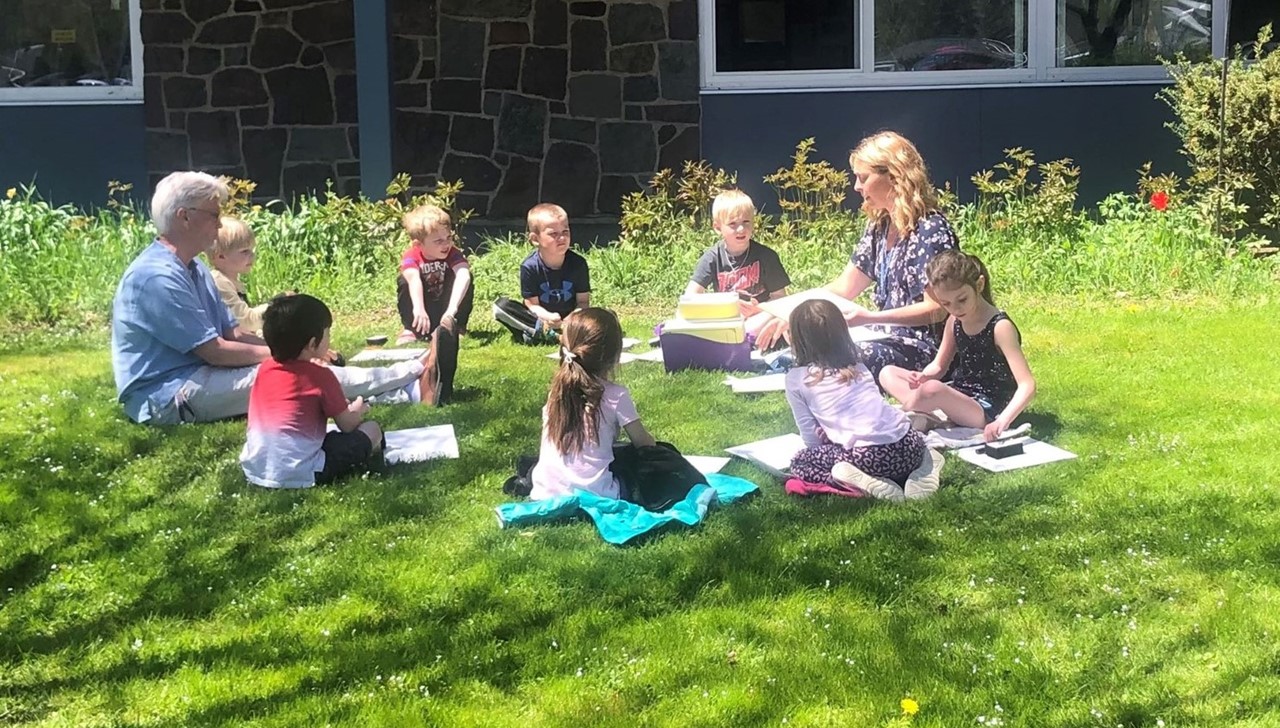 Primary school class working outside on lawn