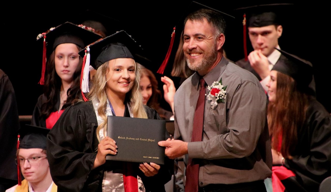 Graduation - Board member handing graduate diploma