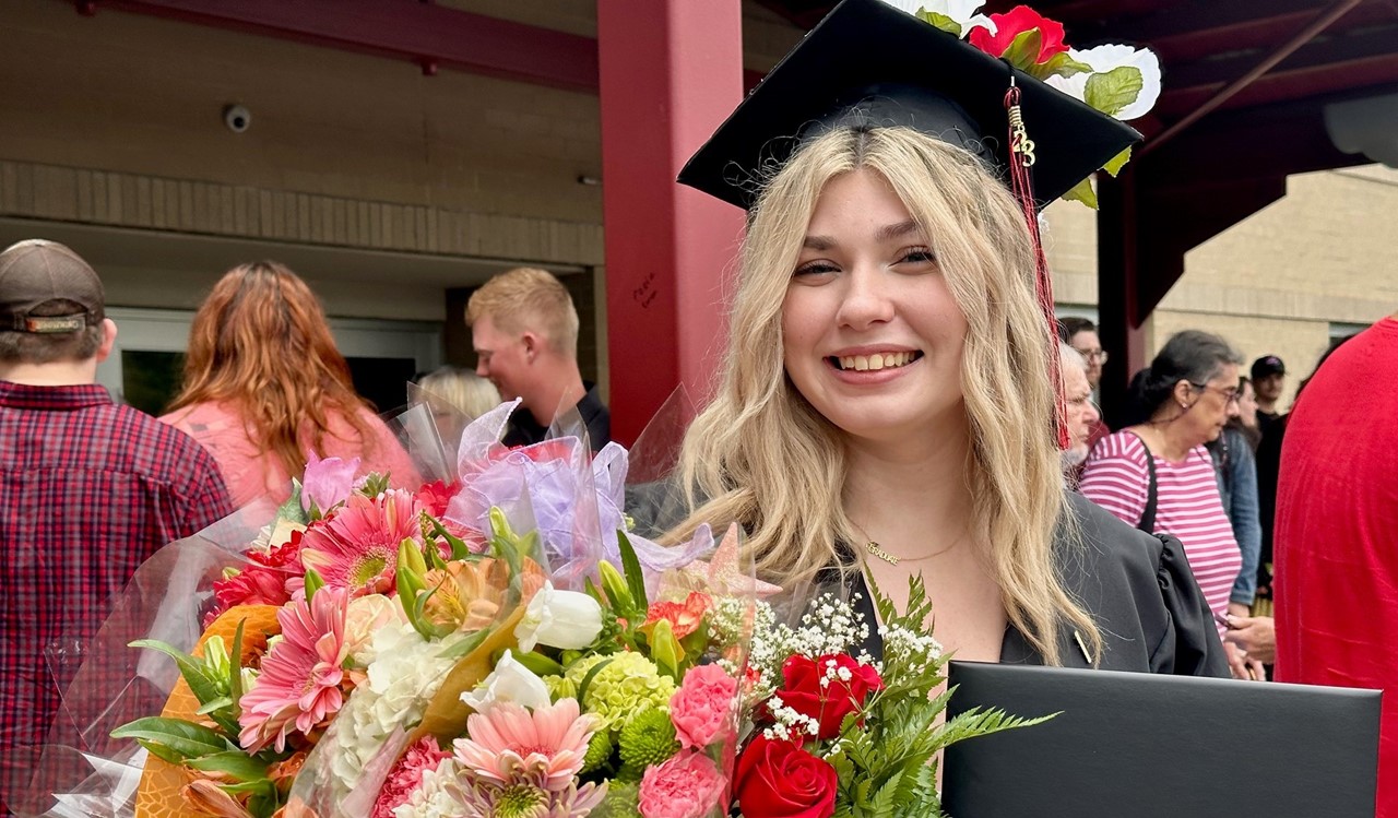 graduate with flowers and diploma