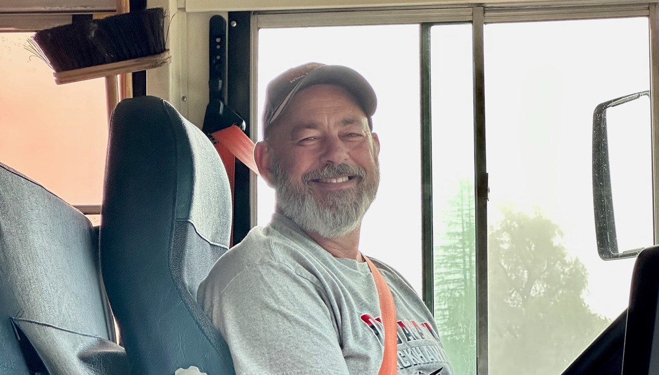 Bus driver behind the wheel posing for the first day of school